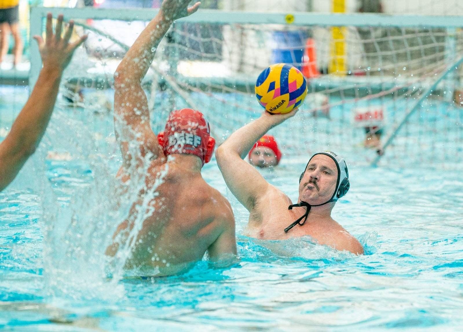 Men's water polo shot blocked at the net